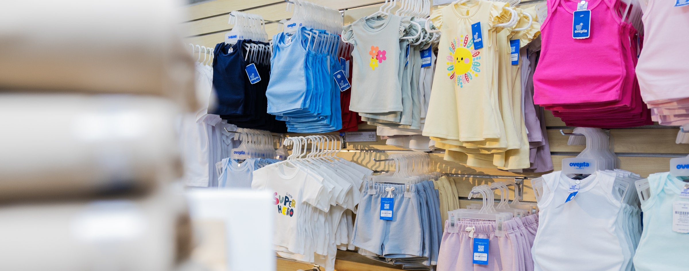 Exhibición real de prendas infantiles en una tienda Ovejita